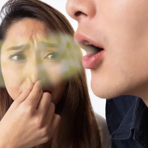 Mujer tapándose la nariz junto a un hombre con aliento visible saliendo de su boca.