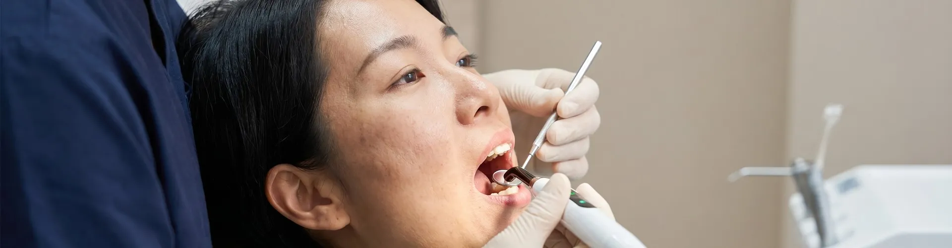 Dentista usando herramientas dentales para examinar a un paciente.
