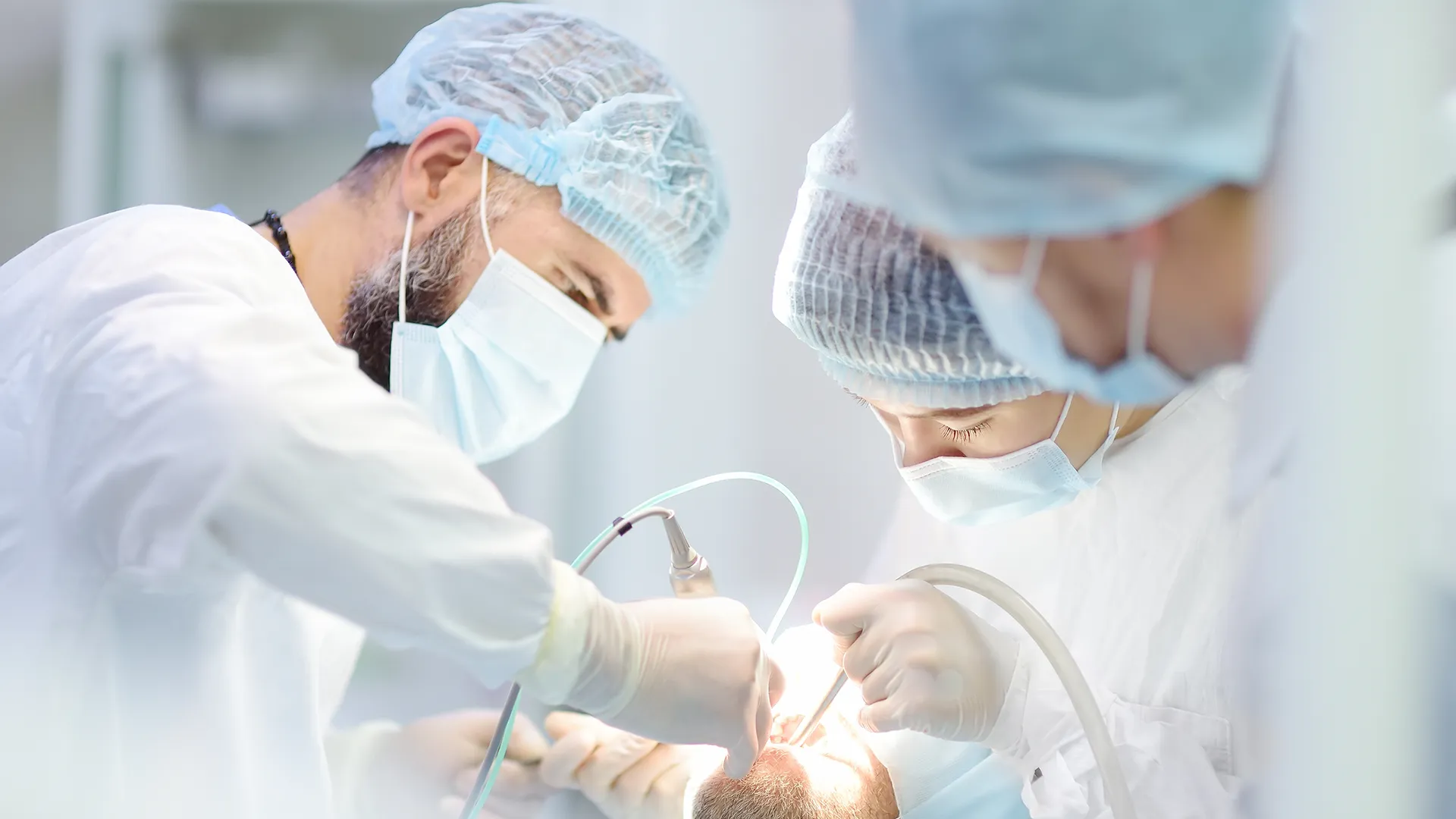 Grupo de cirujanos orales realizando un procedimiento en un paciente.