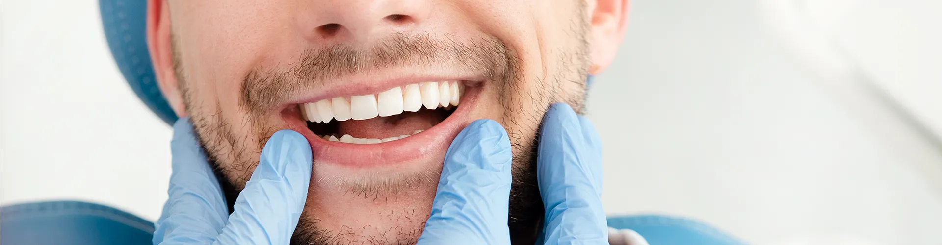 dedos enguantados enmarcando la sonrisa de un hombre