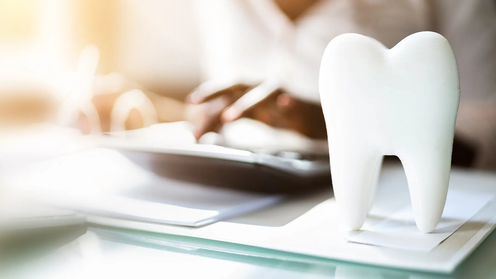 Diente artificial colocado de pie sobre el escritorio del dentista.